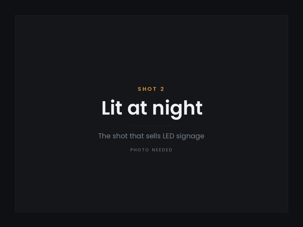 The same sign after dark — front-lit LED, warm white